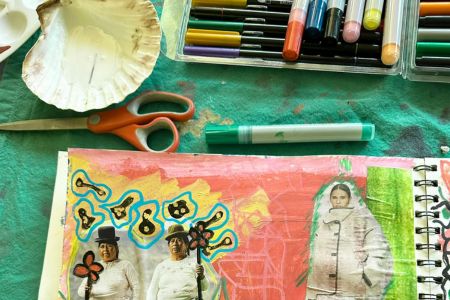 A partially completed collage with pens, paints and scissors, representing clarity in creativity