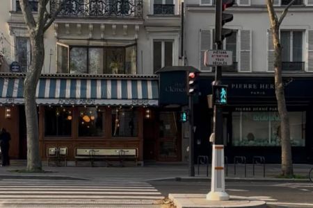 An image of a city street with a pedestrian crossing. The light is green, indicating time to move forward